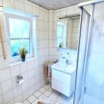 Badezimmer mit Dusche, Waschbecken und Fenster
