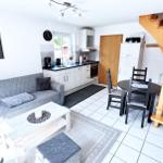 Wohnbereich mit Sofa, Esstisch und Holztreppe.