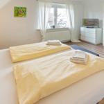 Zimmer mit Doppelbett, Fenster, Schrank und Spiegel