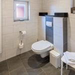 Badezimmer mit Toilette, Heizung und Fenster