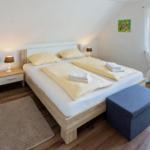 Schlafzimmer mit Doppelbett, Nachttisch und Fenster