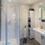 Badezimmer mit Dusche, Waschbecken und Spiegel