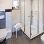 Bad mit Dusche, Toilette und Waschbecken. Duschwanne mit blauen Sternen.