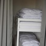 Double bed with white mattress and bedding