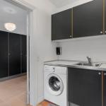 Washing machine and sink in a kitchen with black cabinets.