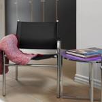 Black chairs with red blanket and purple table with books.