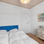 Bedroom with bed, dresser, and ceiling. Wall art and lamp on dresser.