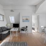 Living and dining area with sofa, table, chairs, and view into bedroom.