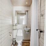 Bathroom with toilet, sink, and shower with shower curtain.