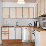 Kitchen with wooden surfaces, sink, dishwasher, and microwave.