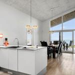 Kitchen with dining area and sea view through large windows.