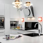 Modern kitchen with stainless steel appliances and white countertop.