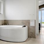 Bath with whirlpool tub, window, and view of the beach.