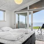 Bedroom with sea view and terrace with lounge chair.