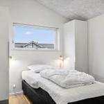 Bedroom with bed, window, and white cabinets.