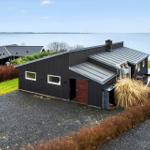 Modern villa with sea view and garden. Entrance door and terrace visible.