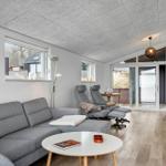 Living room with gray sofa, two chairs, and wooden floor. Entrance to terrace.