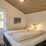 Bedroom with double bed, window, and wooden ceiling.