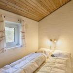 Bedroom with bed, window, and wooden ceiling.