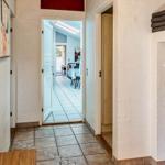 Hallway with closet, artwork, and view into dining area.