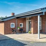 Single-story brick house with terrace and sun loungers.