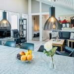 Dining room with dining table, sofa, and fireplace in background.