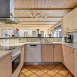 Kitchen with wooden ceiling, countertops, and appliances.