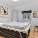 Bedroom with bed, wardrobe, and window with view of trees.