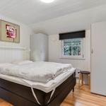 Bedroom with bed, window, and closets. Wooden floor and white walls.