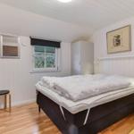 Bedroom with bed, wardrobes, and window with view of trees.