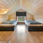 Two beds in a room with wooden walls and ceiling. Window with view outside.
