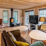 Living room with fireplace, sofa, and TV. Passage to shower and view of outdoor area.