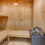 Sauna with wooden walls, benches, and stone bin