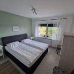 Schlafzimmer mit Doppelbett, Fenster und Schrank.