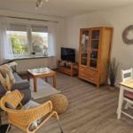 Wohnzimmer mit Sofa, Esstisch und Küchenmöbel. Holzmöbel und Fenster mit Blick.
