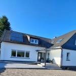 Hauseingang mit Überdachung und Sonnenterrasse im Grünen