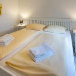 Schlafzimmer mit Doppelbett, zwei Nachttischen und Bettwäsche.