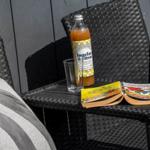 Auf der Terrasse steht ein Getränk und ein geöffnetes Buch auf einem Stuhl.