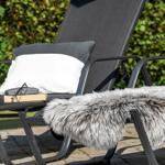 Schwarze Liegestühle mit Kissen und Felldecke auf Terrasse