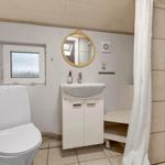 Badezimmer mit Toilette, Waschbecken und Dusche mit Vorhang.