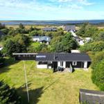 Schwarzes Haus mit Garten und Blick auf Wasser