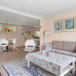 Wohn- und Essbereich mit Sofa, Tisch und Stühlen. Wandbildern und Holzboden.