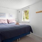 Schlafzimmer mit Bett, Fenster und Bücherregal.