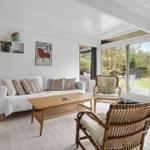Wohnzimmer mit Sofa, Stühlen und Blick auf die Terrasse
