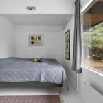 Schlafzimmer mit Bett, Fenster und Balkonansicht.