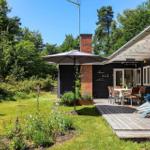Haus mit Terrasse, Garten und Grillplatz. Holzterrasse mit Sitzgelegenheiten und Sonnenschutz.