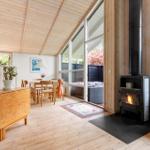 Holzgetäfelte Küche mit Esstisch, Kamin und großem Fensterblick.