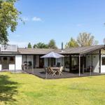Ein Haus mit Terrasse, Garten und Sonnenschirm. Satellitenschüssel und Antenne sind sichtbar.