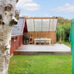 Terrasse mit Sitzgelegenheit und Grillbereich neben rotem Haus