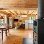 Holzhaus mit Kamin, Esstisch und Küchenbereich.